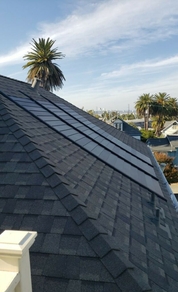 A rooftop in Galt with newly installed solar panels by DavisRoofingGroup, featuring palm trees and an expansive sky in the background.